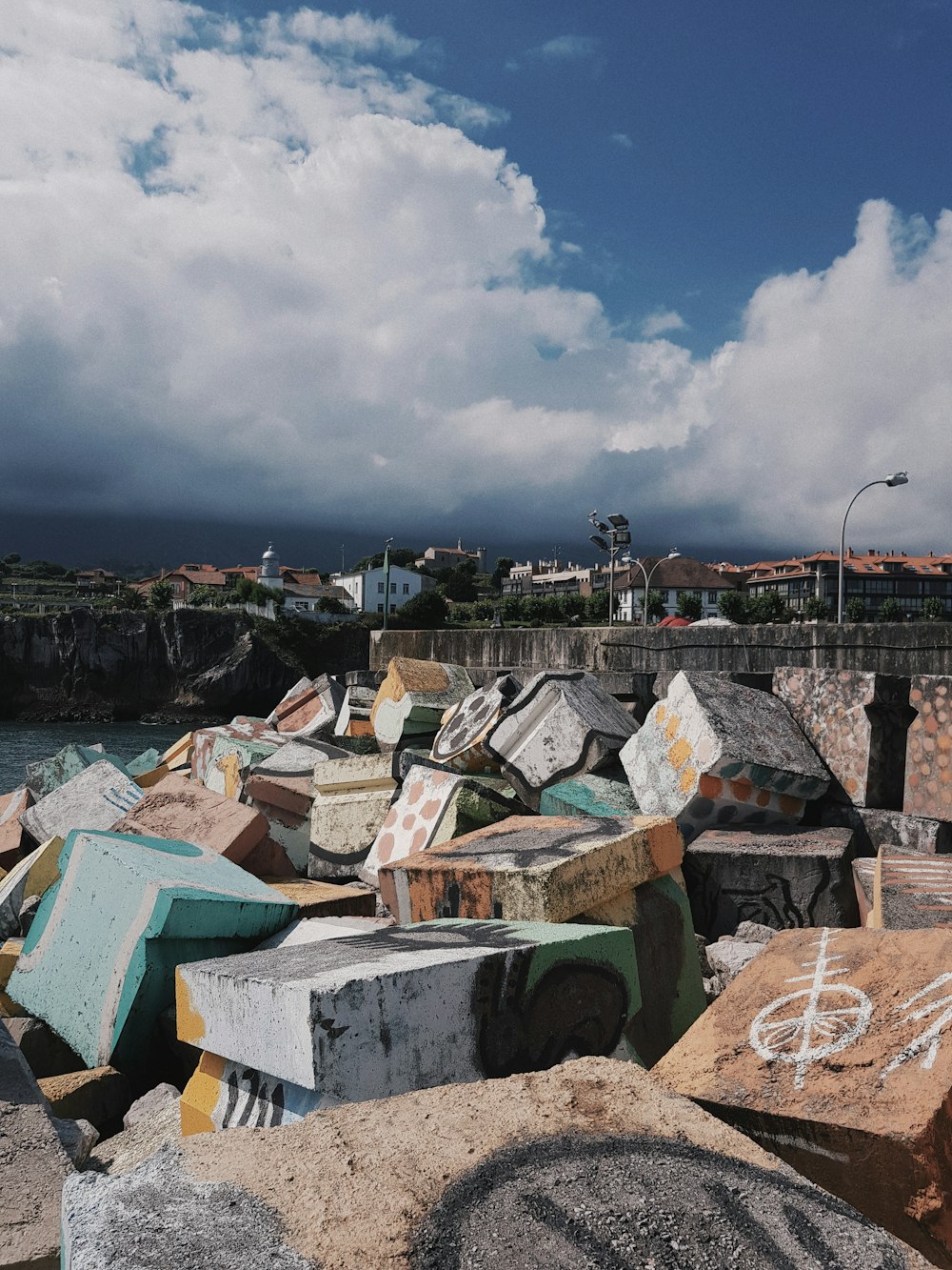 houses near body of water under white clouds during daytime