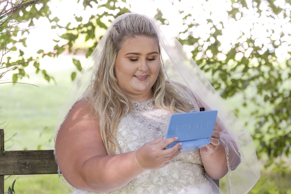 smiling woman holding blue tablet computer