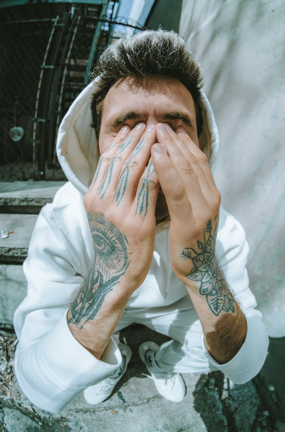 man in white shirt covering his face with white textile