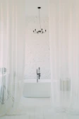 Bathroom with minimalist design, black fixtures, and subtle mood lighting.