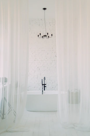 A serene bathroom scene featuring a minimalist bathtub with a stylish wall-mounted faucet.