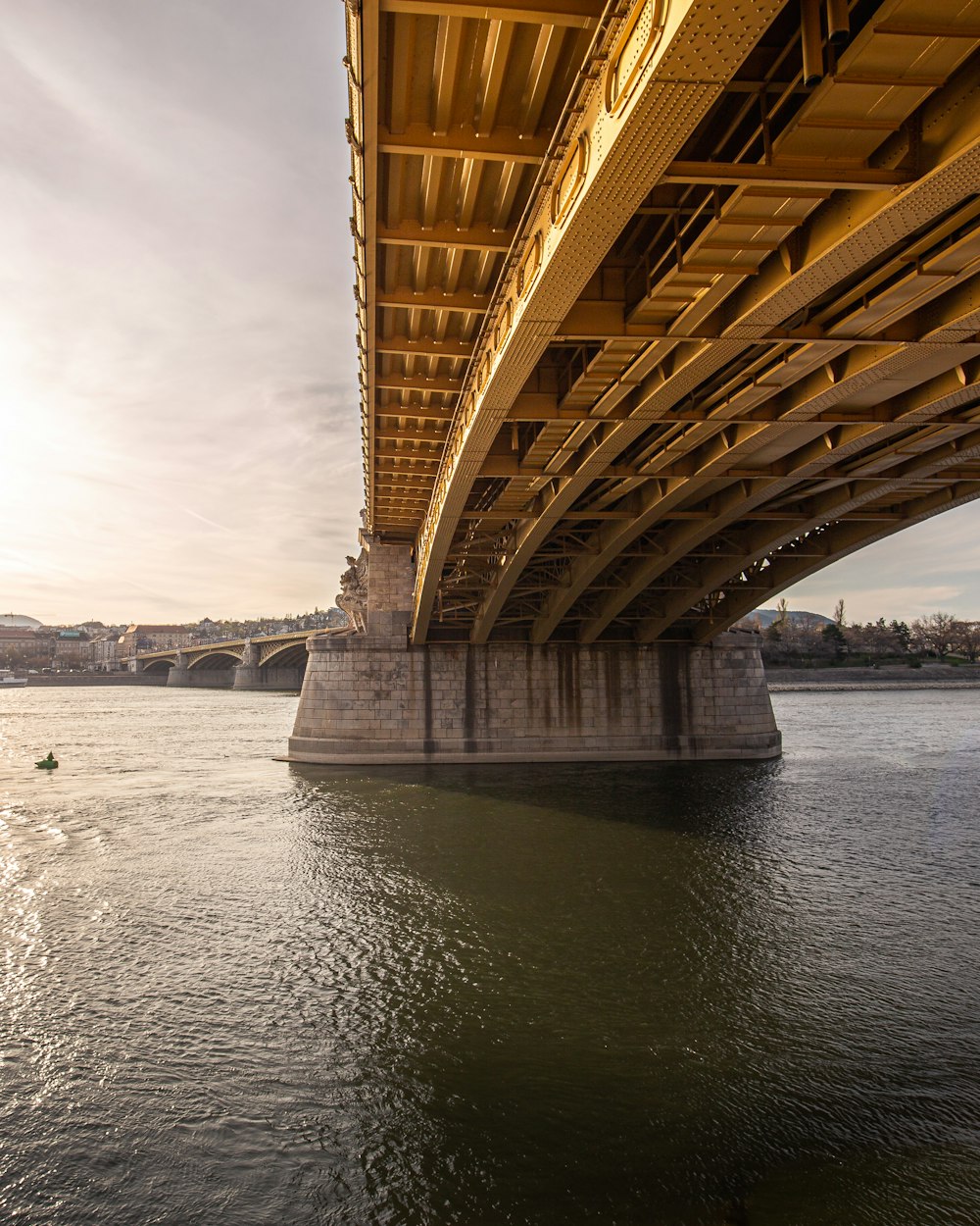 brown bridge over body of water under white sky during daytime