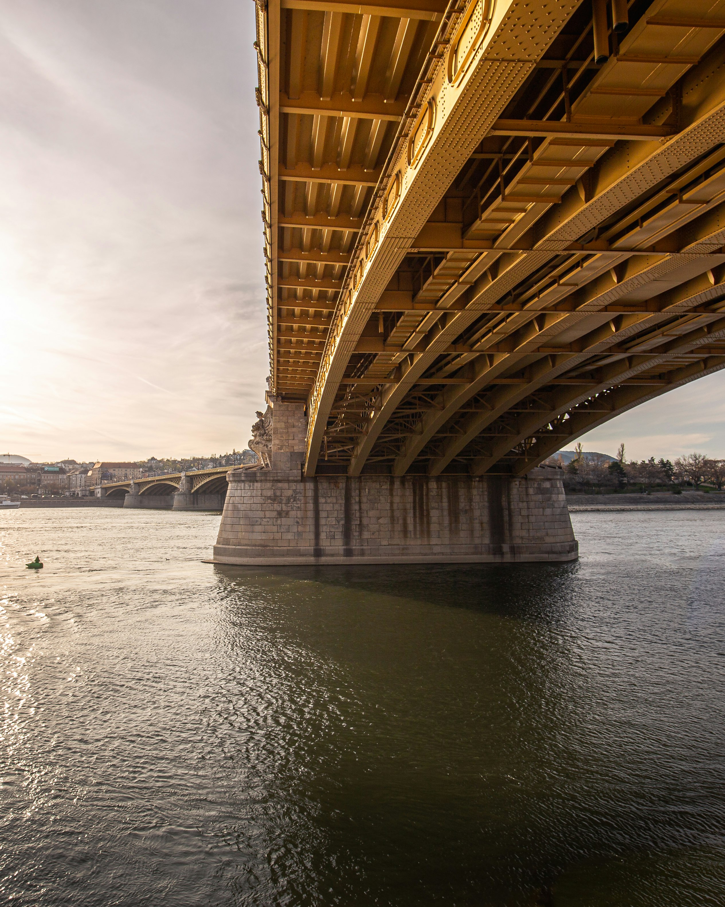 brown bridge over body of water under white sky during daytime