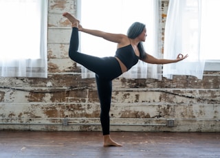 woman in black tank top and leggings doing yoga