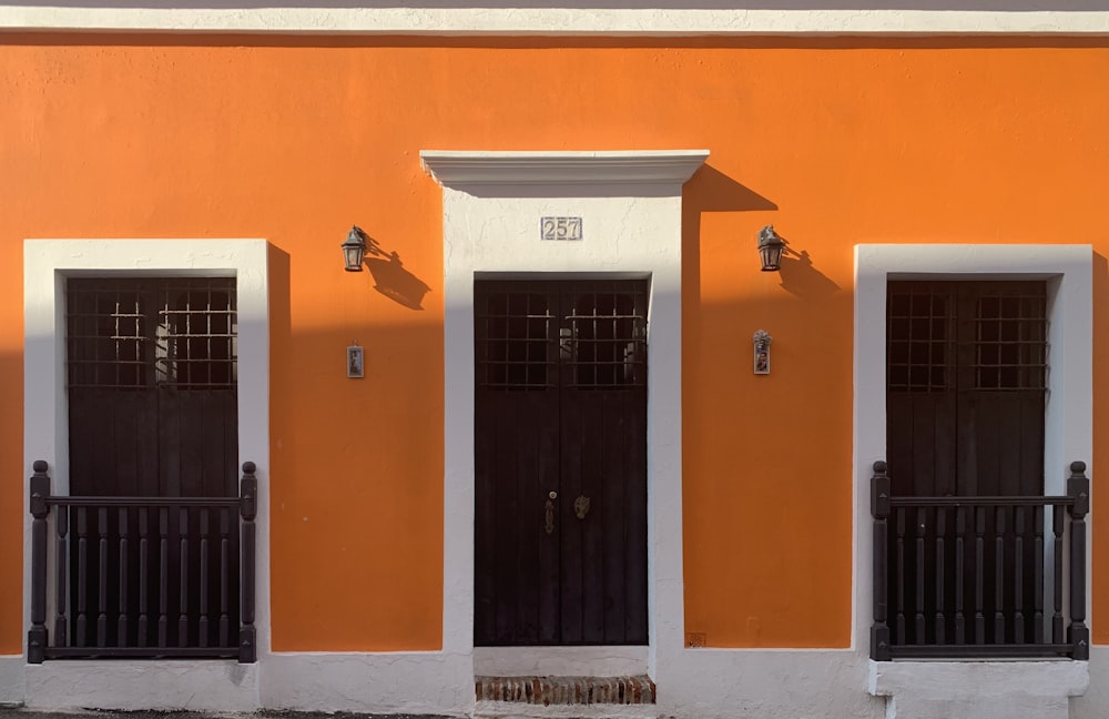 edifício pintado de laranja e branco com porta de madeira branca