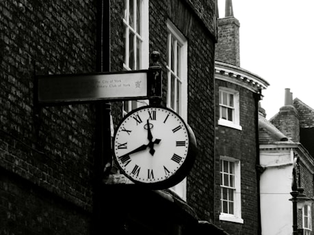 grayscale photo of round analog clock at 10 00
