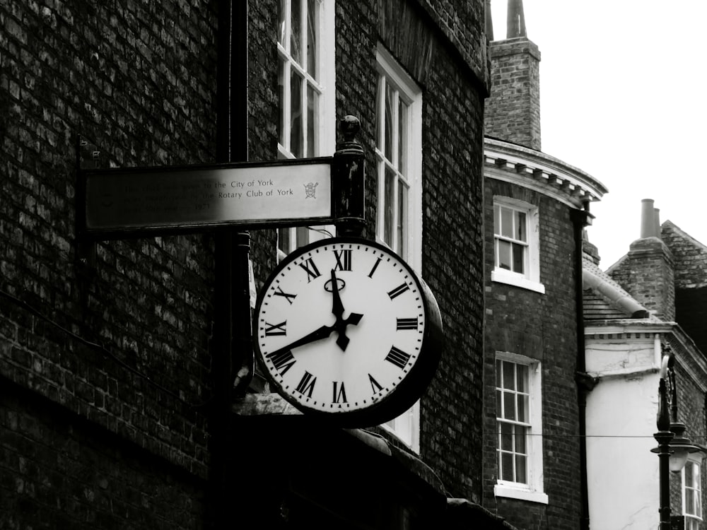 grayscale photo of round analog clock at 10 00