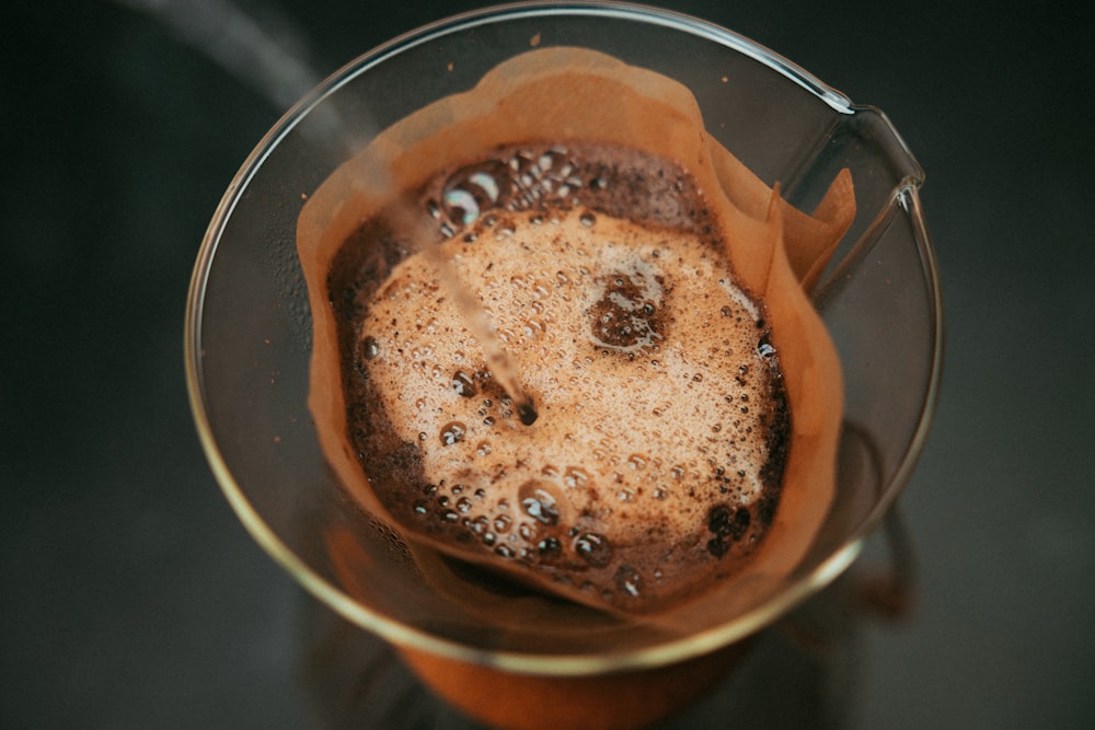 clear drinking glass with brown liquid