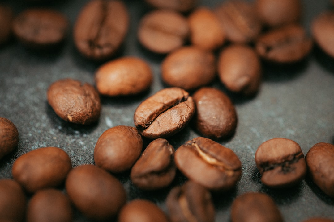 brown coffee beans on black surface