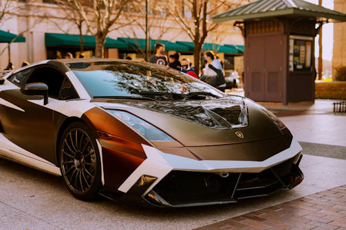 Workers expertly installing a bold vehicle wrap on a sleek car in an urban setting.