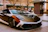 A sleek car with a bright, eye-catching custom wrap parked on a city street.