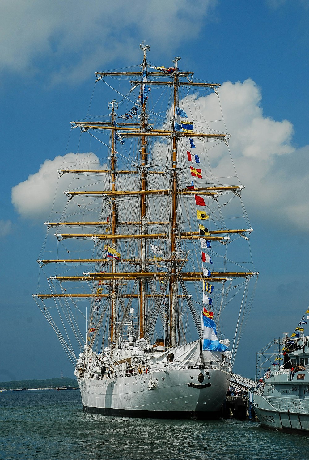 white and brown ship on sea under white clouds and blue sky during daytime