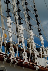 Close-up of rigging chains and shackles arranged neatly on a steel surface.
