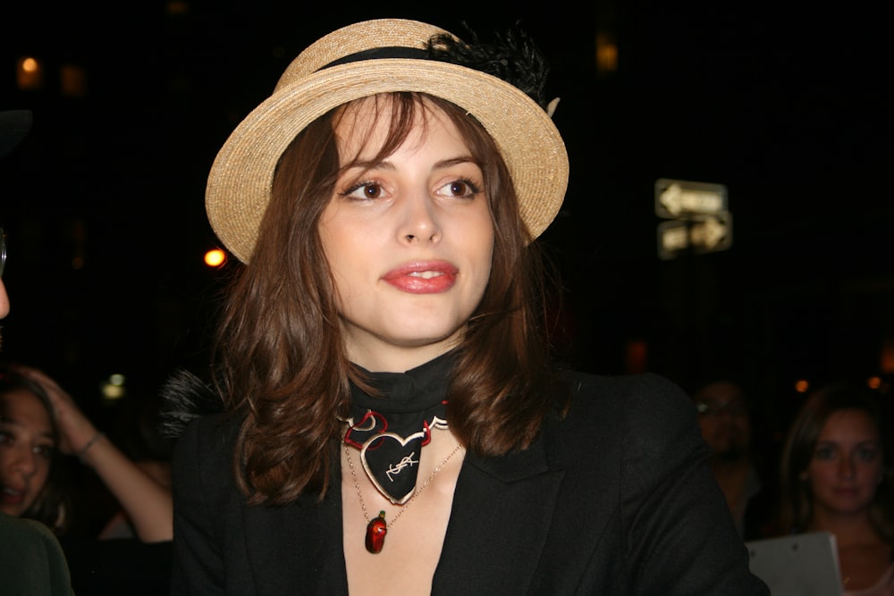 Mujer con blazer negro y sombrero marrón