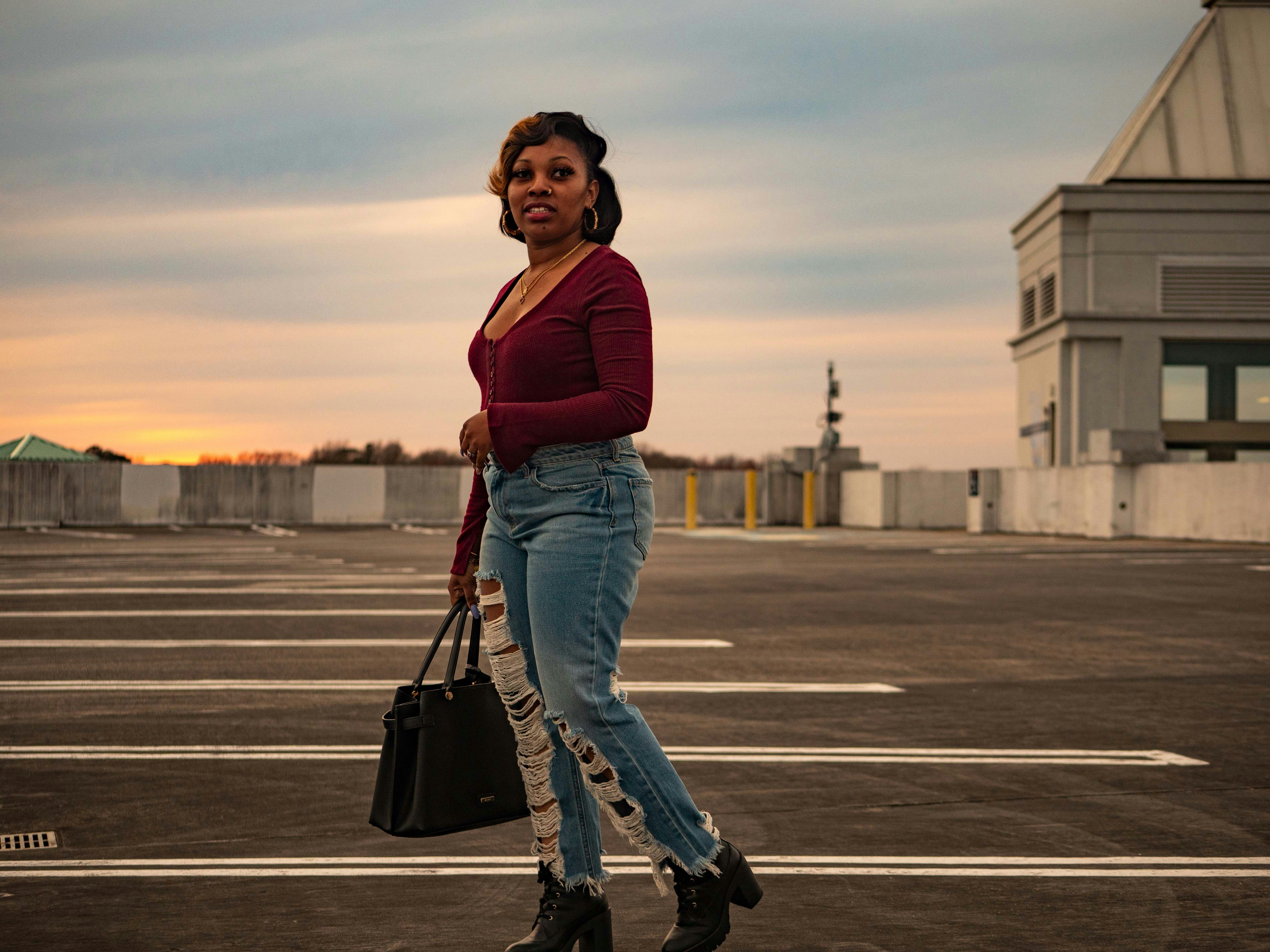 man in red long sleeve shirt and blue denim jeans walking on road during daytime