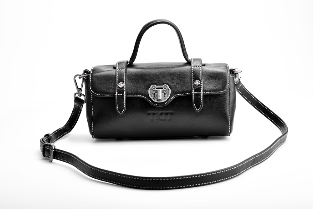 black leather handbag on white surface