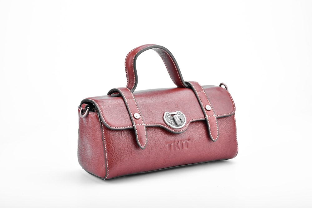 pink leather handbag on white surface