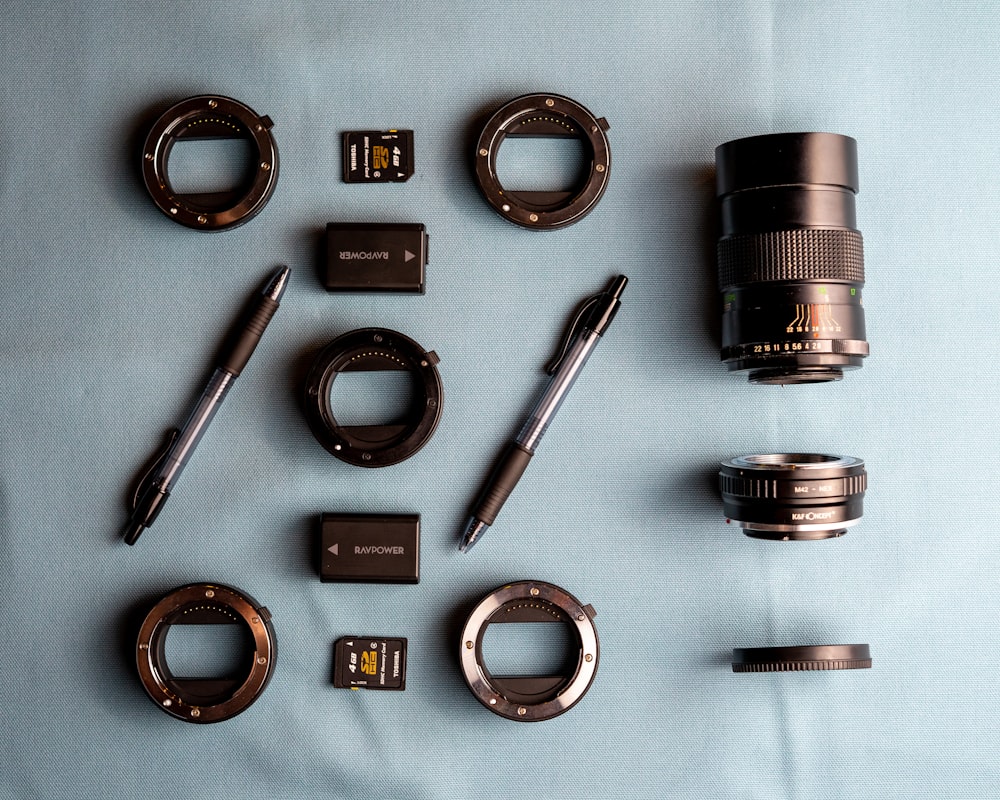 black dslr camera lens beside silver and black click pen