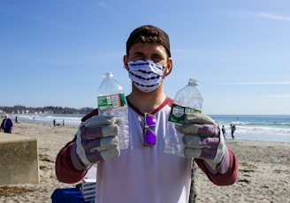 man in white shirt holding bottled water