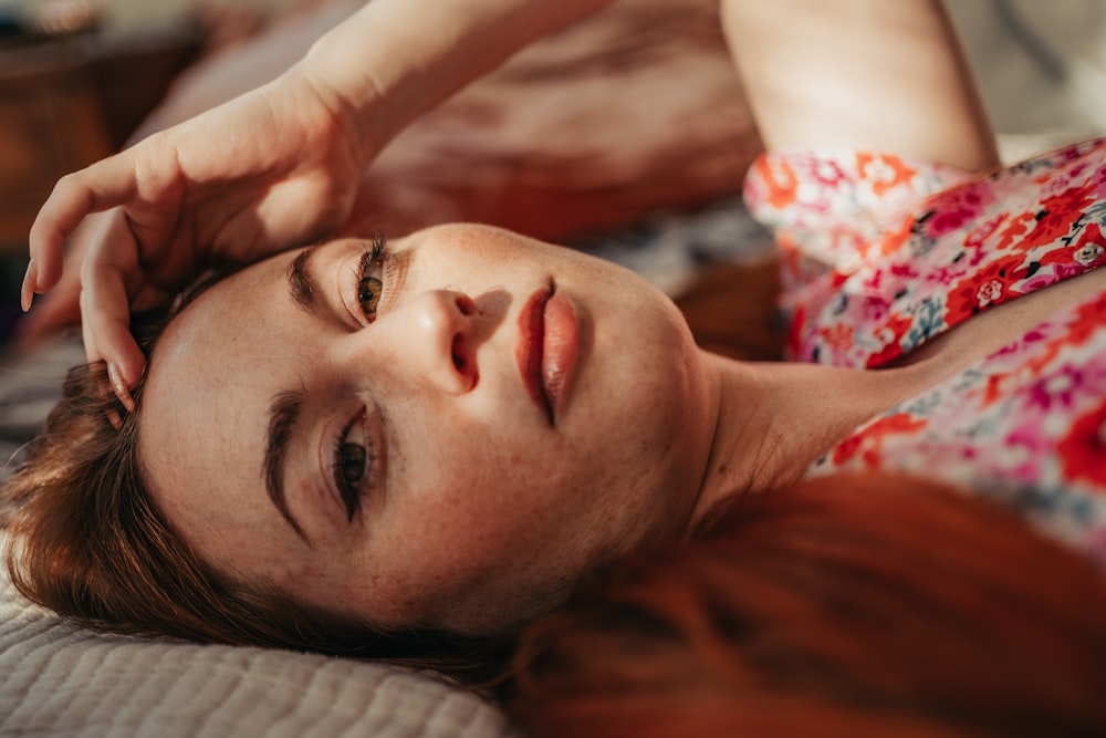 man in red and white floral shirt lying on bed