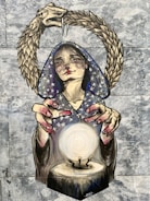A mural depicts a figure with a star-patterned hood, gazing intently at a glowing orb. Their hands are positioned around the orb, giving the impression of mystical power or fortune-telling. Above, a serpent arches in a complete circle, with its head biting its tail. The artwork is set against a mottled gray background.