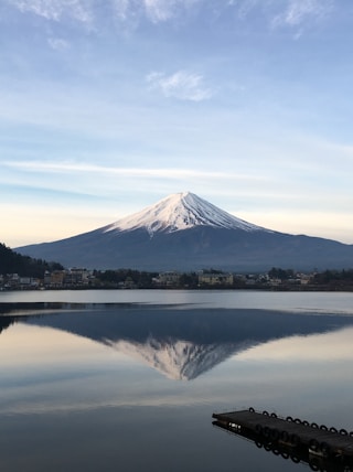 body of water near mountain under blue sky during daytime