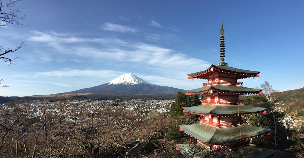 red and white temple near mountain under blue sky during daytime