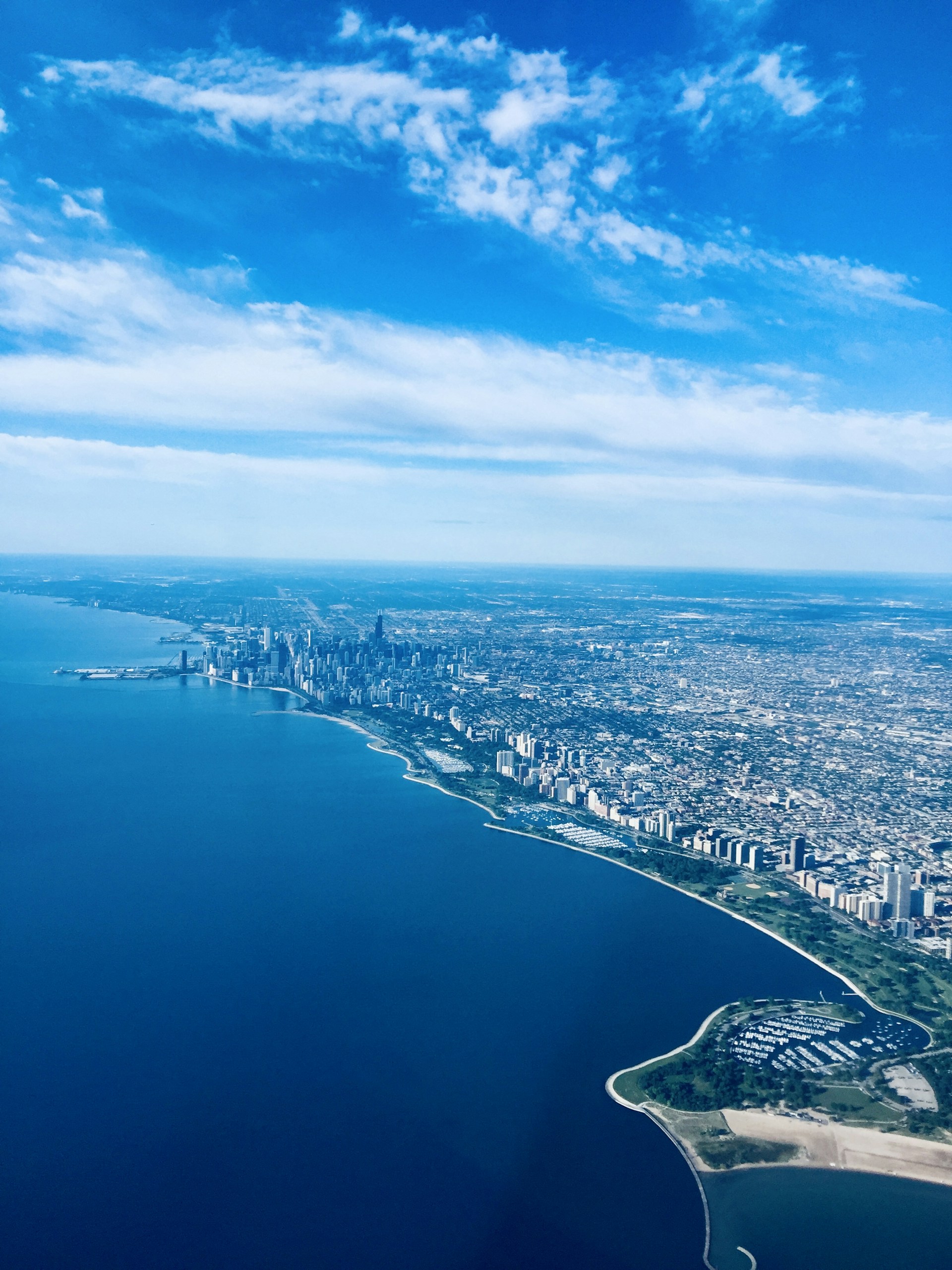 A stunning aerial view captured from the top of a tall tower showing a sprawling cityscape under a clear sky.