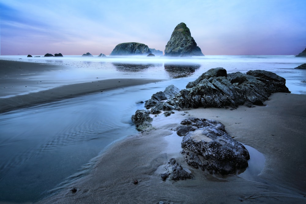 black rock formation on sea shore during daytime