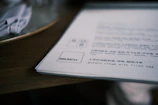 A close-up of a restaurant menu featuring a green badge QR code next to sustainable dish descriptions.