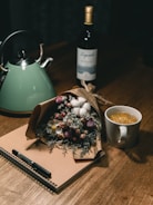 A cozy journal and pen next to a cup of herbal tea on a bright morning table