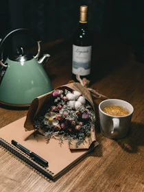 A serene scene of a journal, pen, and calming tea on a wooden table.