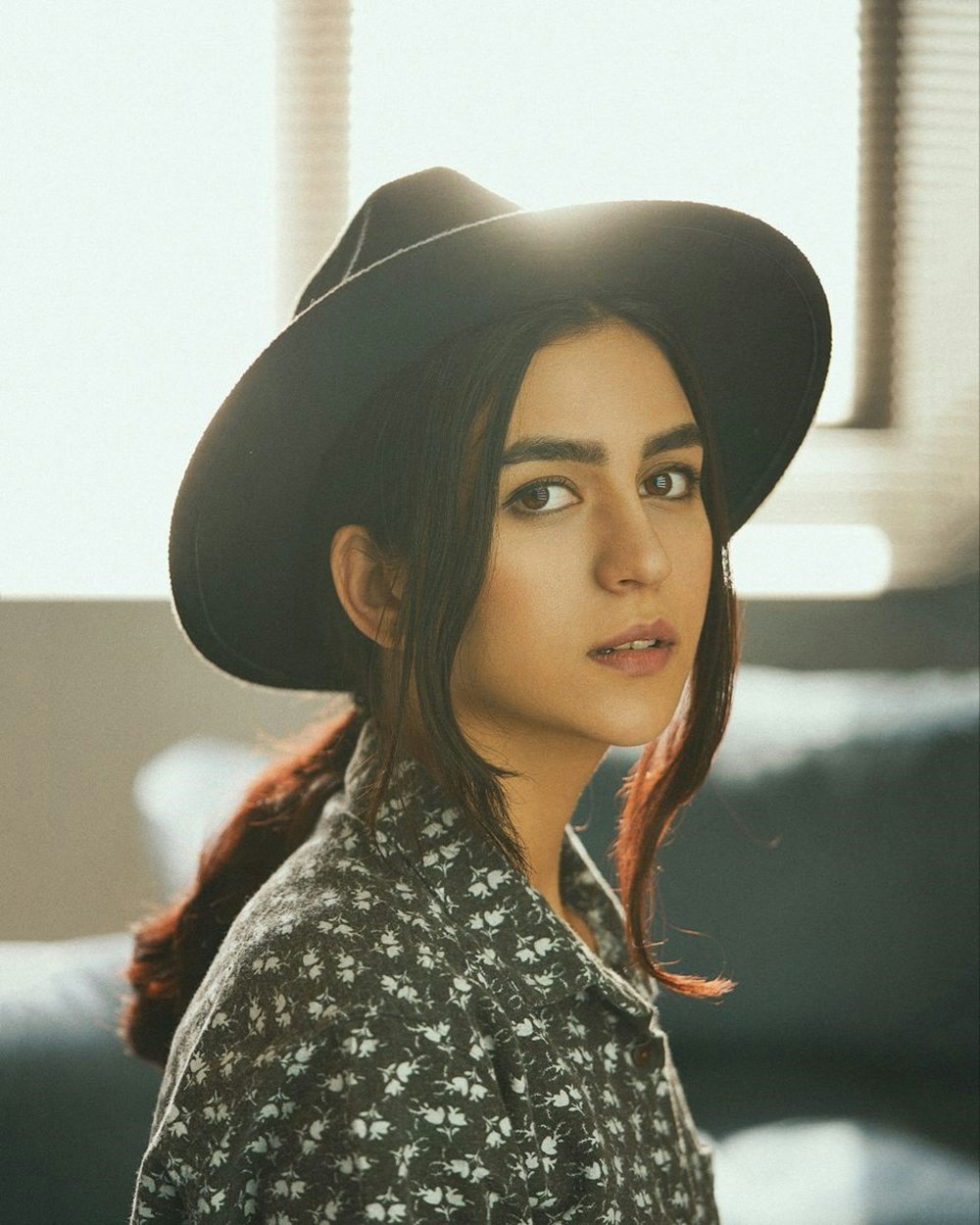 woman in black hat and black and white floral shirt