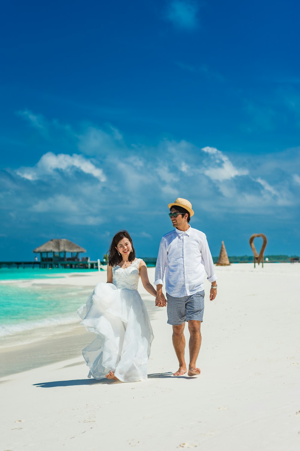 man and woman standing on beach during daytime