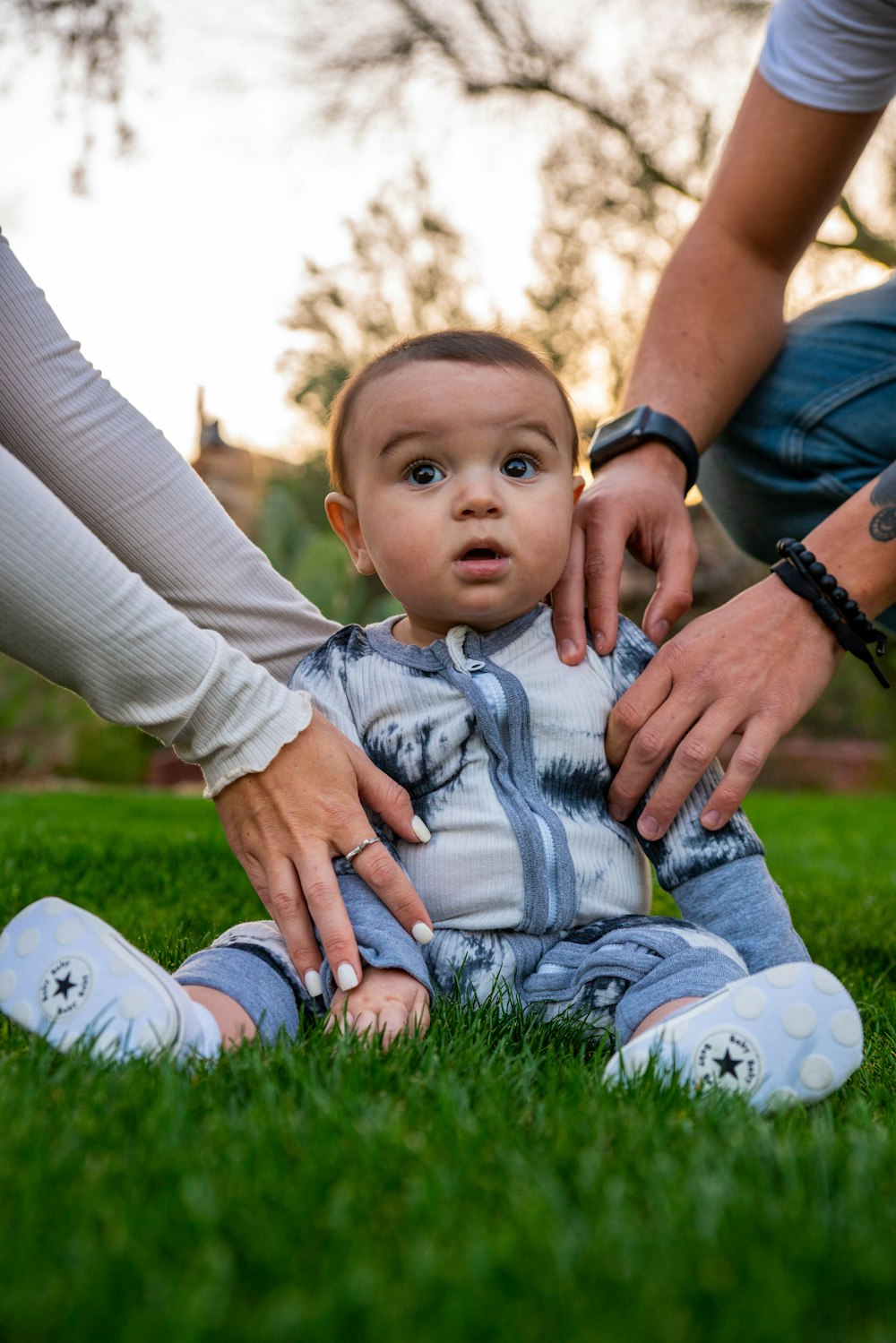 woman in gray long sleeve shirt carrying baby in white long sleeve shirt