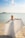 woman in white dress standing on beach during daytime