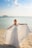 woman in white dress standing on beach during daytime