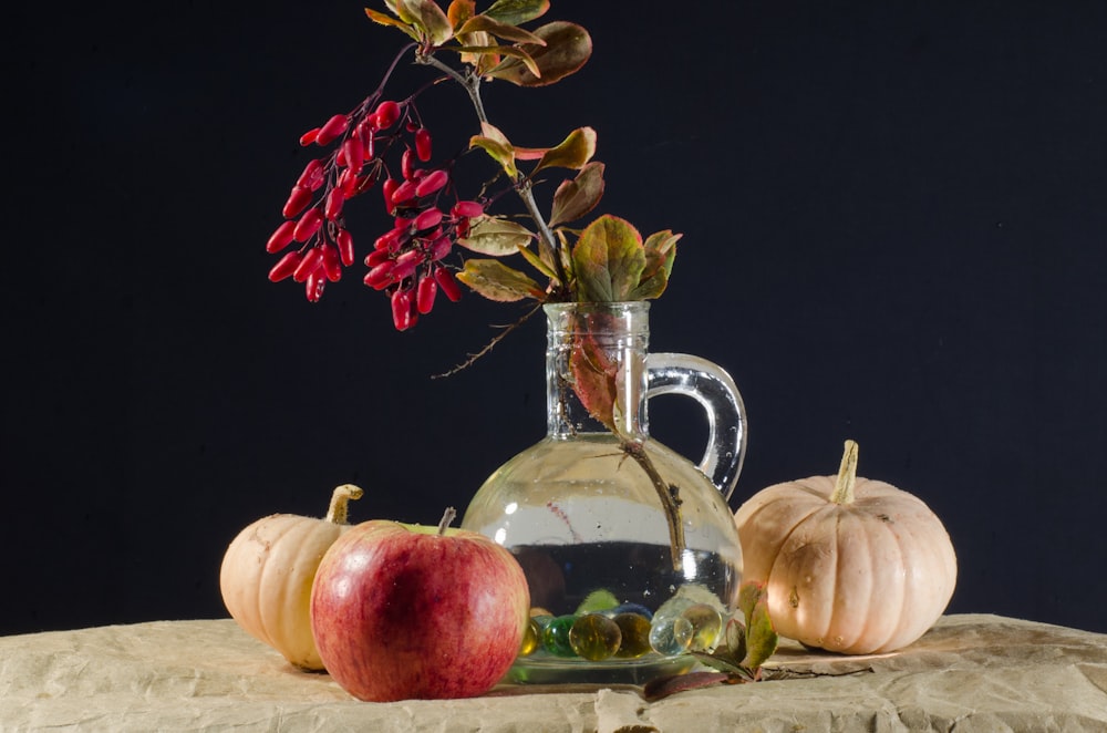 red apple fruit beside clear glass pitcher