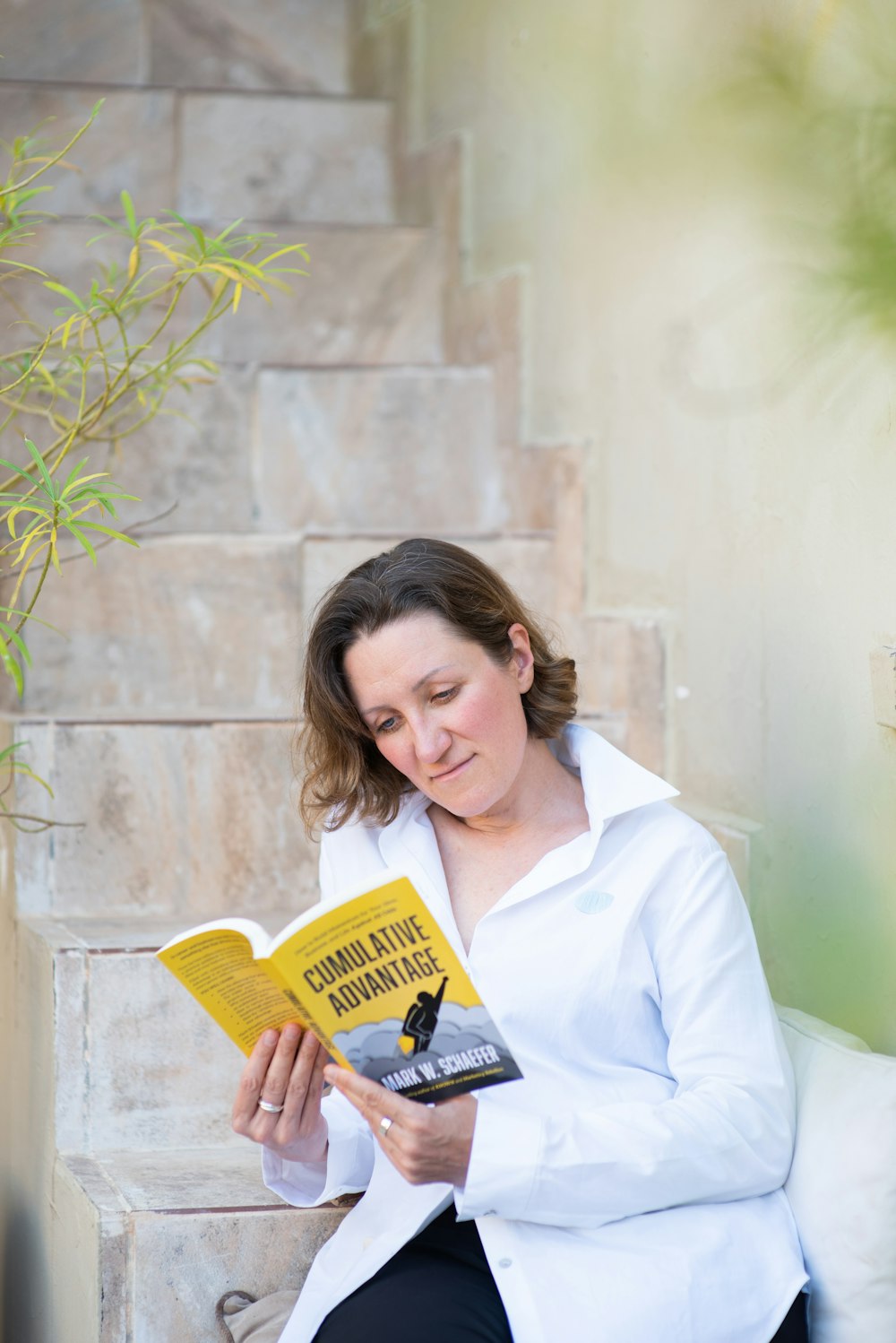 Frau im weißen Hemd mit gelbem Buch