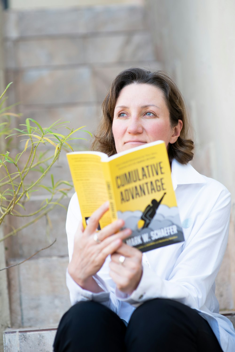 woman in white long sleeve shirt holding book