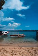A serene beach scene with turquoise waters and a colorful boat anchored nearby.