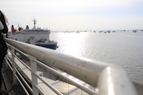 Passengers boarding a water taxi at a busy harbor dock.