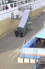 A ship docked at port with crew and agents coordinating operations.