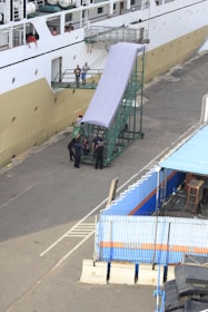 A ship docked at port with crew and agents coordinating operations.