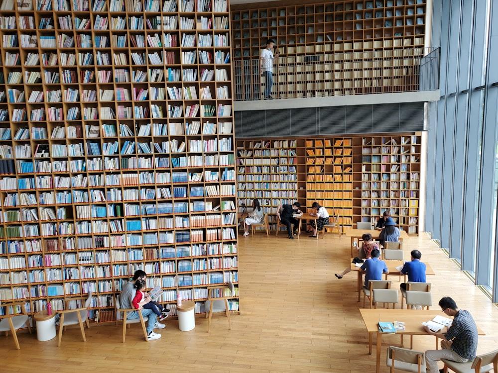 personnes assises sur une chaise à l’intérieur de la bibliothèque