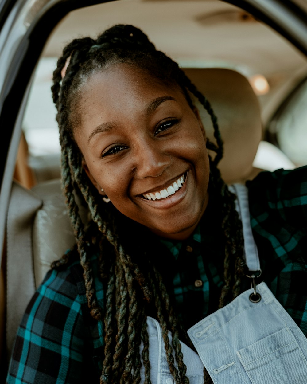 smiling woman in blue and black plaid shirt