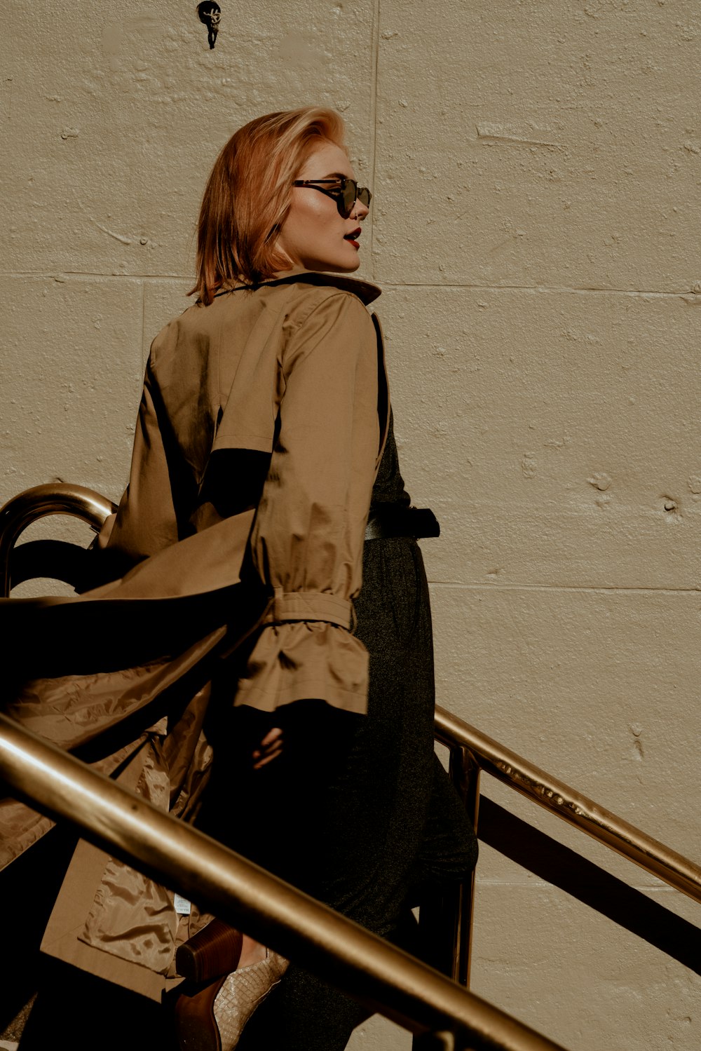 woman in black coat standing on stairs