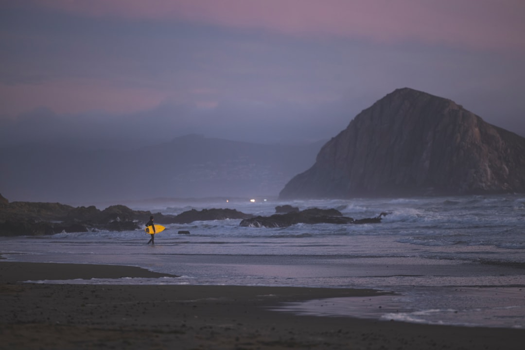 person in yellow shirt walking on beach during daytime