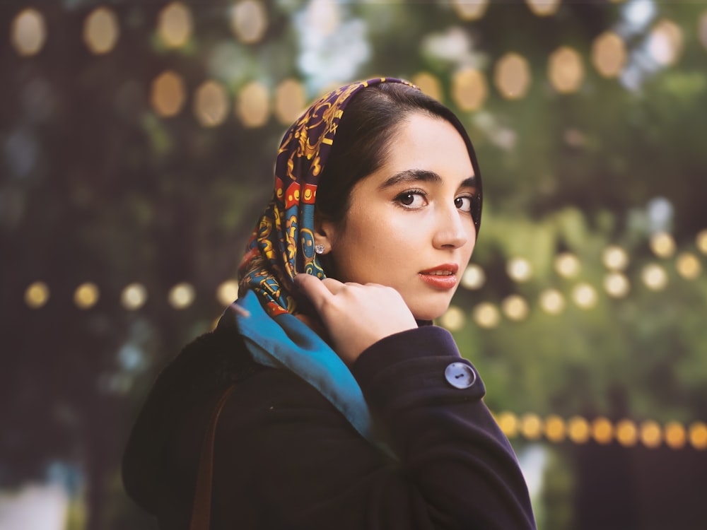 woman in black jacket with blue and brown scarf