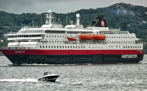 A friendly travel agent assisting a customer with ferry booking on a laptop